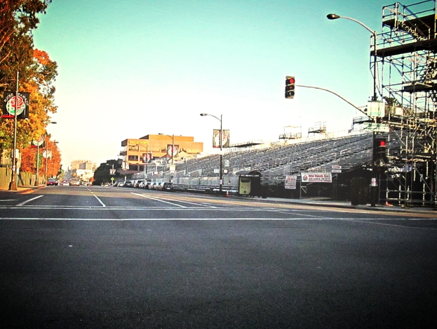 Eine Straße mit einer Ampelstange und Equipment auf der rechten Seite, Warnschilder und mehrere Fahrzeuge auf der linken Seite und Bäume im Hintergrund.