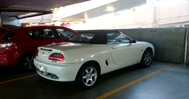 Fahrzeuge in einem Keller mit einem Rohr am Dach und einem weiteren Gebäude oben rechts.