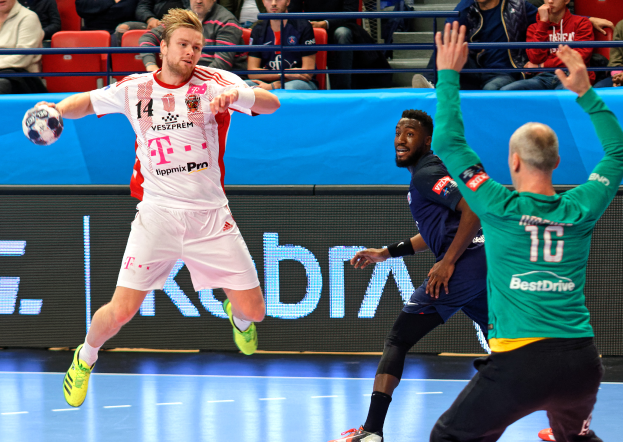 Eine Gruppe von Männern, die auf einem Handballfeld Handball spielen, mit einem Ball in der Mitte der Aktion und Zuschauern im Hintergrund, die das Spiel beobachten, das Teil der Futsal-Weltmeisterschaft 2019 zwischen Bayern München und Paris Saint-Germain ist.