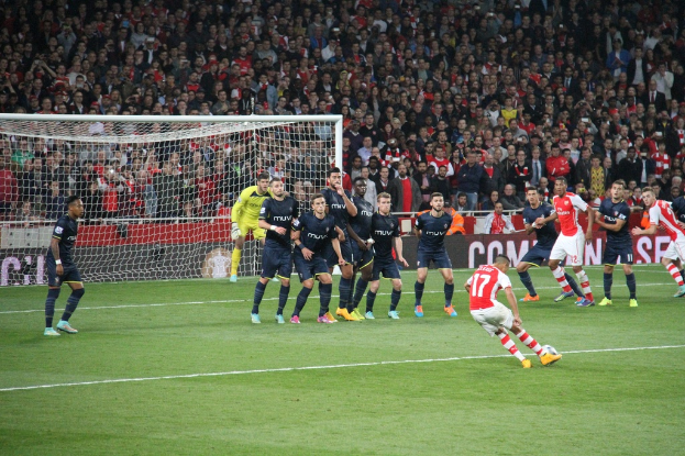 Fußballspieler auf einem Feld mit einer grossen Menge im Hintergrund.