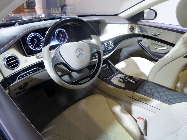 Das Innere eines Mercedes S-Klasse Limousinen zeigt ein luxuriöses Lenkrad, bequeme Sitze, ein elegantes Armaturenbrett mit verschiedenen Knöpfen und Bedienelementen sowie ein großes Touchscreen-Display.