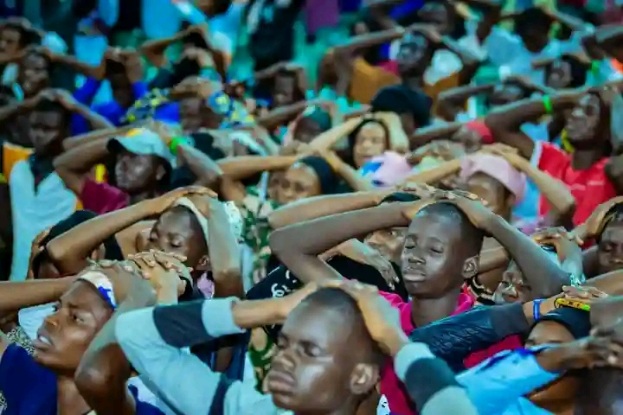 Eine große Gruppe von Menschen, die zusammen sitzen und fröhlich zu feiern scheinen, mit einem unscharfen Hintergrund.