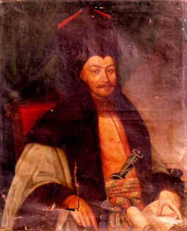 Ein Mann in einem langen Gewand sitzt in einem Stuhl, hält ein Buch und einen Stift, mit einem ernsten und nachdenklichen Ausdruck, schaut in die Ferne.