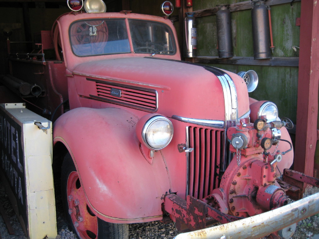 Ein Kraftfahrzeug steht auf einem steinbedeckten Boden mit Feuerlöschern, die an der Wand neben ihm angebracht sind.