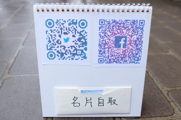 Ein Notizbuch mit einem QR-Code und handgeschriebener Text liegt auf dem Boden.