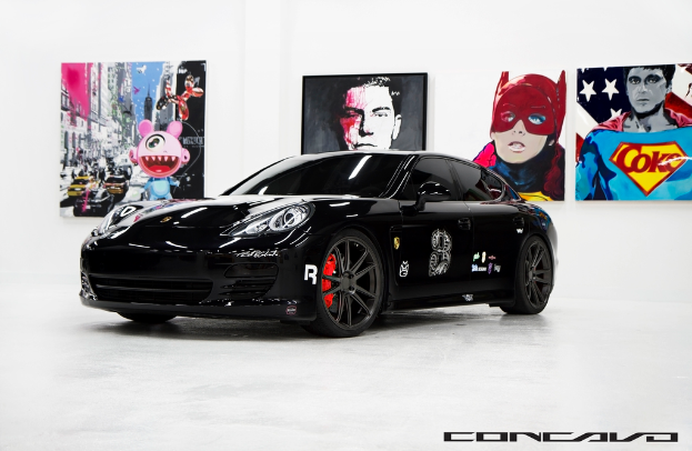 Ein schwarzer Nissan-Sportwagen mit Cartoons im Hintergrund und einer kleinen Inschrift unten.