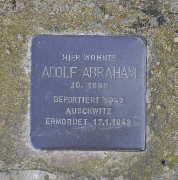 Plakette auf einer Steinwand mit der Inschrift "Adolf Abraham".