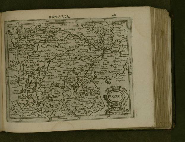 Offenes Buch mit detaillierter Karte von Bayern mit sichtbaren Städten, Dörfern und begleitendem beschreibendem Text.