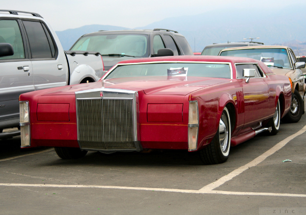 Fahrzeuge auf einer Straße mit Bergen im Hintergrund.