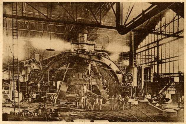 Schwarz-weiß-Foto eines Fabrikinneren mit Arbeitern, die eine große Maschine bedienen, umgeben von Leitern und Stangen, beschriftet mit "Cadillac Steel Works" unten.