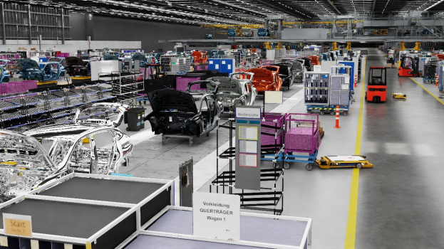 Große Fabrik-Montagelinie mit zahlreichen Autos, Metallstrukturen auf beiden Seiten, einer Wand im Hintergrund und Deckenlampen, wahrscheinlich eine Volkswagen-Anlage in Deutschland.