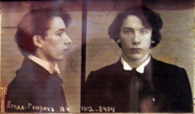 Ein Bild eines Mannes in einem schwarzen Anzug, weißem Hemd und schwarzer Krawatte mit ernster Miene, gefesselten Händen und zurückgekämmtem Haar, begleitet von zwei kleineren Bildern von ihm und fett gedrucktem Text über seine Verbrechen.