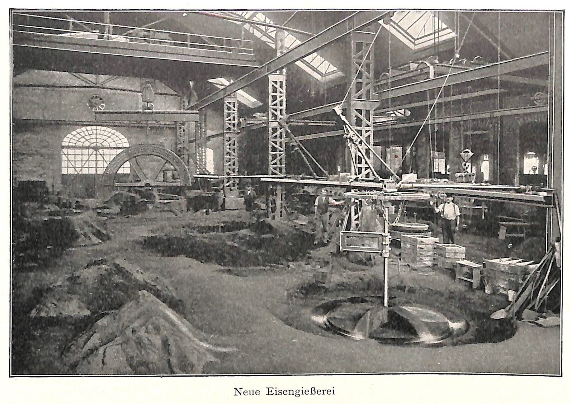 Ein altes Schwarz-Weiß-Foto einer Fabrik mit Arbeitern, die an einer Maschine arbeiten, umgeben von Metallstangen und -pfählen, mit dem Text "Neue Eisenglebeerei, die erste Fabrik Deutschlands" unten.