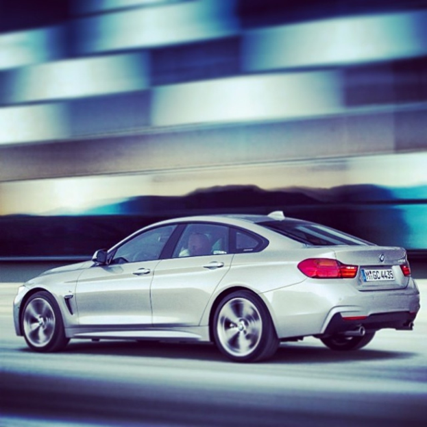 Ein graues Fahrzeug auf einer Straße mit einem unscharfen Hintergrund.