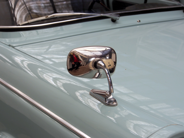 Ein Nahaufnahme eines Autos Seitenspiegels, der am Fahrzeug befestigt ist und die Umgebung reflektiert, verleiht dem Auto ein elegantes und modernes Aussehen.