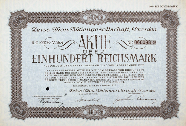 Alter deutscher Aktienchein für 100 Reichmarks mit schwarzem Rand und gedrucktem Text.