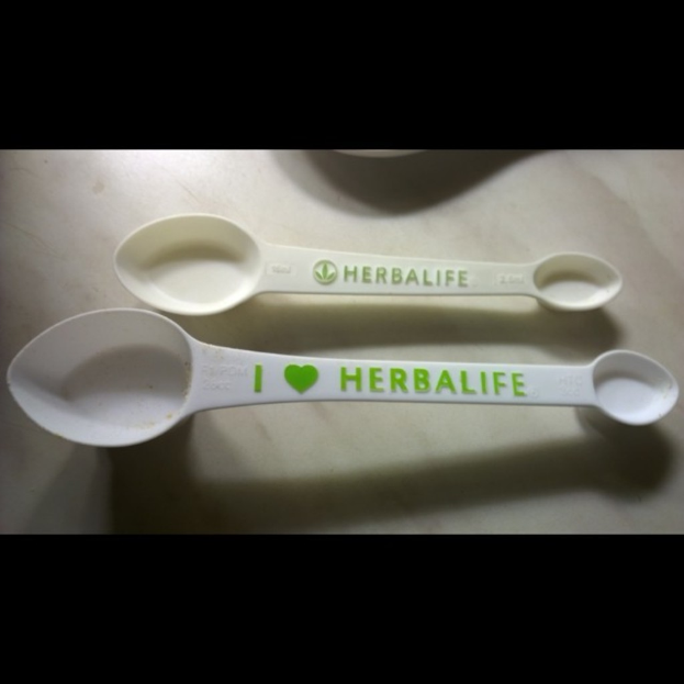 Ein Tisch mit einem Löffel, auf dem "Herbalife" steht.