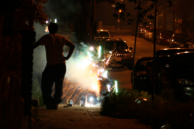 Ein Mann steht auf einer Straße mit Raketen, Fahrzeugen, Bäumen und Ampeln im Hintergrund.