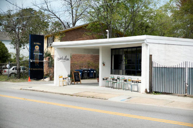 Ein Restaurantgebäude, das neben einer Straße liegt, mit Bäumen im Hintergrund
