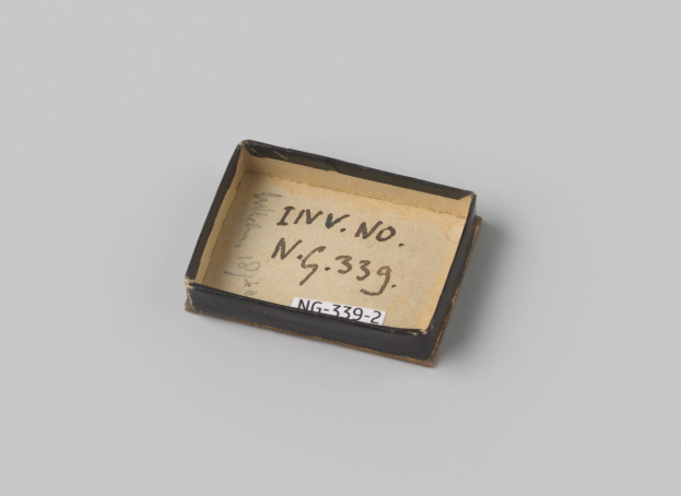 Kleiner schwarzer Kasten mit weißer Beschriftung auf weißer Oberfläche, Beschriftung hat Text.