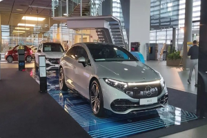 Ein Mercedes-Benz S-Klasse Coupé wird auf der Internationalen Automobil-Ausstellung in Frankfurt präsentiert, umgeben von einer Glaswand, Treppen und Lichtern, mit mehreren Bewunderern.