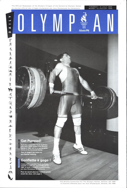 Schwarzes und weißes Foto eines Mannes in einem Gewichtheber-Outfit, der eine Hantel stemmt, mit dem Text "Olympian Magazine" oben und einem entschlossenen Gesichtsausdruck.