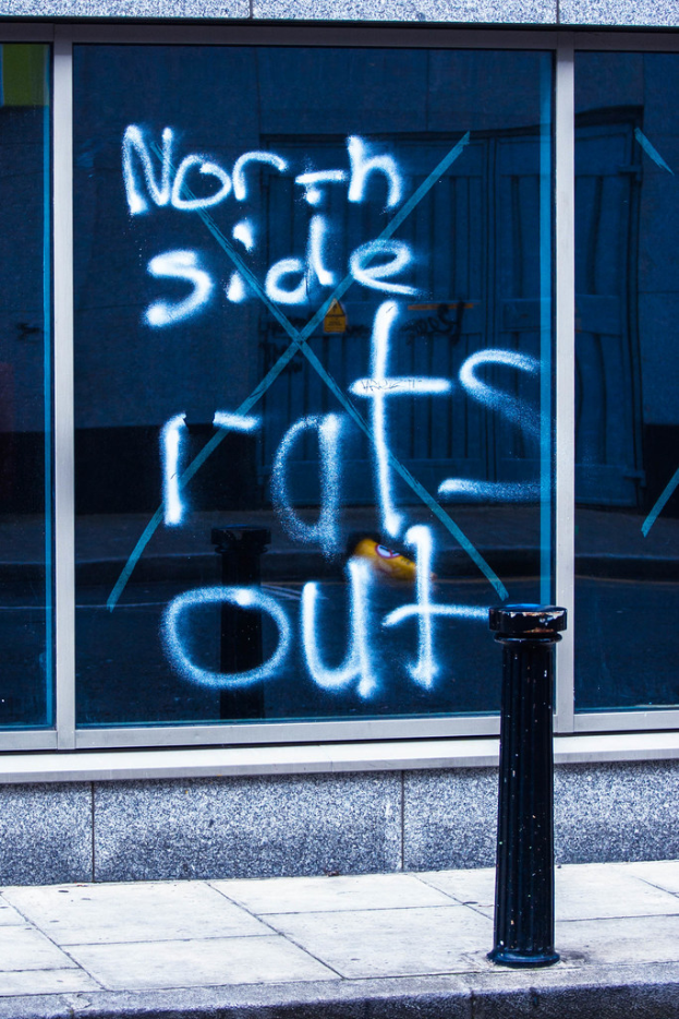 Text auf einem Fenster und ein Absperrpfahl auf der Straße.