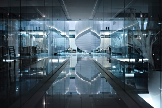 Das Innere eines Geb├Ąudes mit St├╝hlen, Lichtern und Glast├╝ren, mit einem sichtbaren Boden am unteren Ende des Bildes.