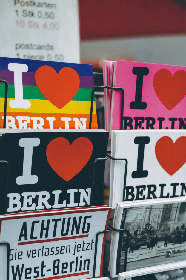 Ein Gestell mit verschiedenen Büchern und Postern, auf denen "Ich liebe Berlin" steht, vor einem unscharfen Hintergrund.