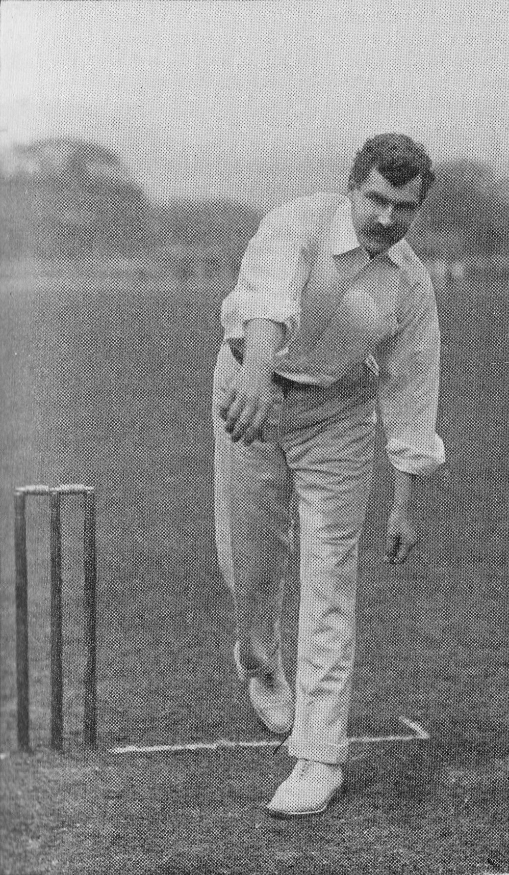 Ein Mann in weißem Hemd und Hose spielt Cricket mit Wickets auf dem Boden, Bäumen und Himmel im Hintergrund und Text, der unten 'Cricket-Spieler des Jahres' liest.