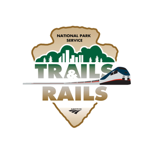 Ein Logo mit einem zentralen Zug, umgeben von Bäumen und Text, in Blau- und Grüntönen.